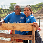 Male and female Project Blueprint participants holding a pallet at a volunteer project