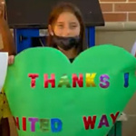 Kid holding up a sign that says thank you United Way