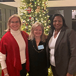 Three WI members posing in front of a Christmas tree